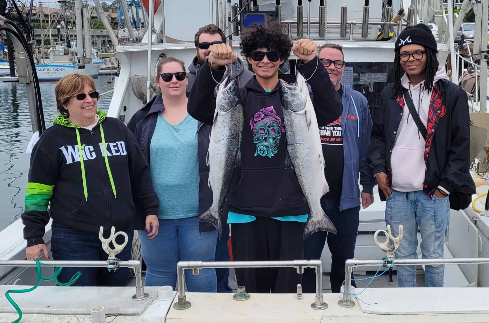 Group of anglers with caught fish at dock