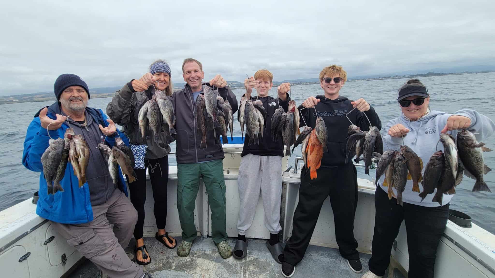 Group of anglers with caught fish on boat